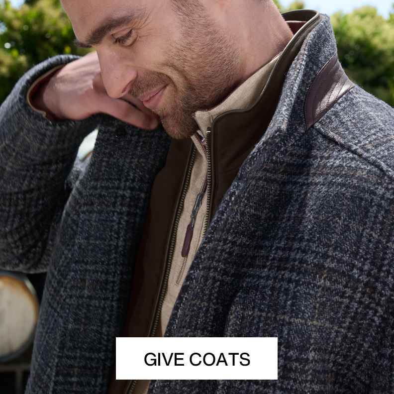 Close up shot of a mans partial face wearing a blue and brown plaid coat.